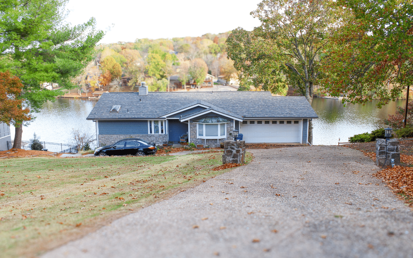 House with grey roof and grey siding beside a lake by siding contractors in Rogers, AR