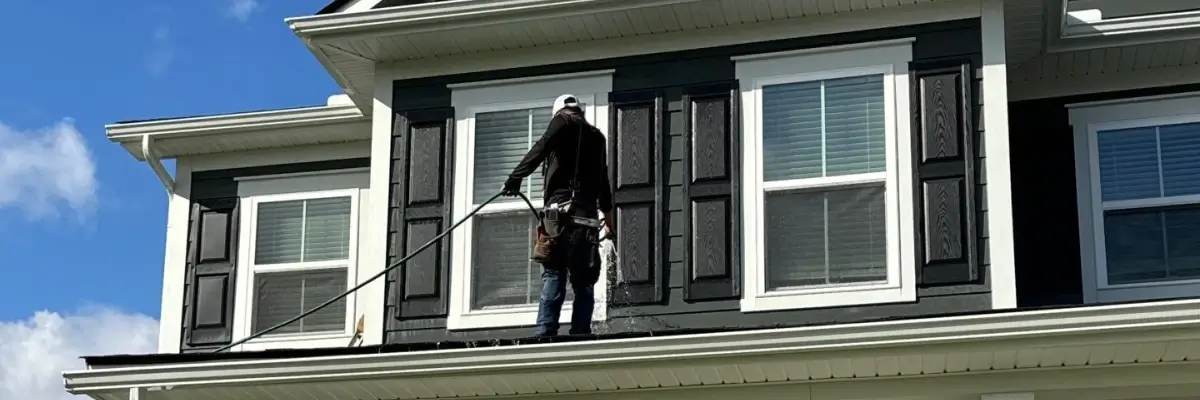 Choosing a siding contractor in Nixa, MO with technician inspecting and washing exterior home siding by Xtreme Exteriors