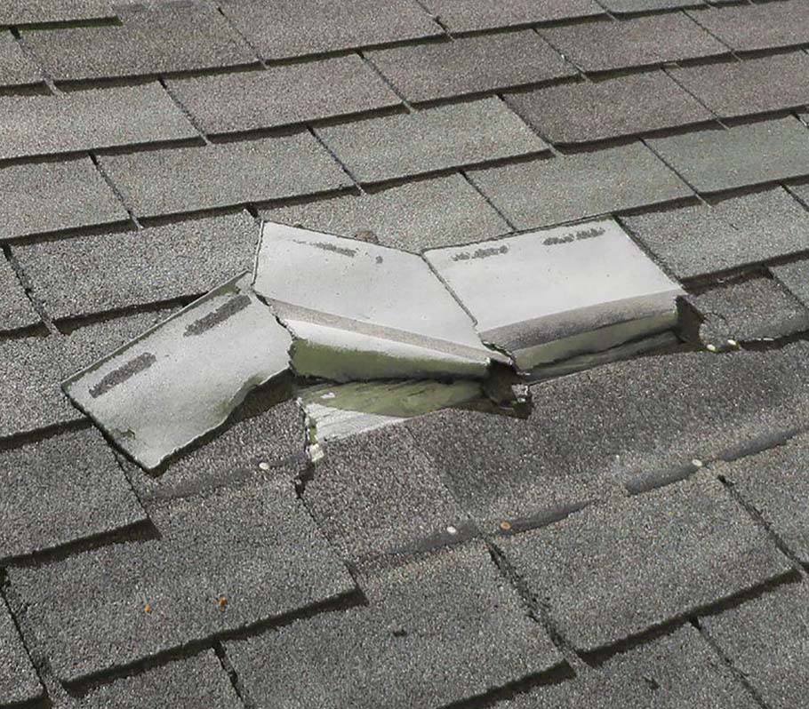 Damaged shingles on a roof close up