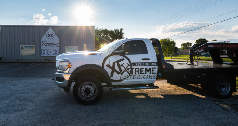 Xtreme Exteriors wrapped truck with gooseneck trailer in front of Xtreme exteriors building