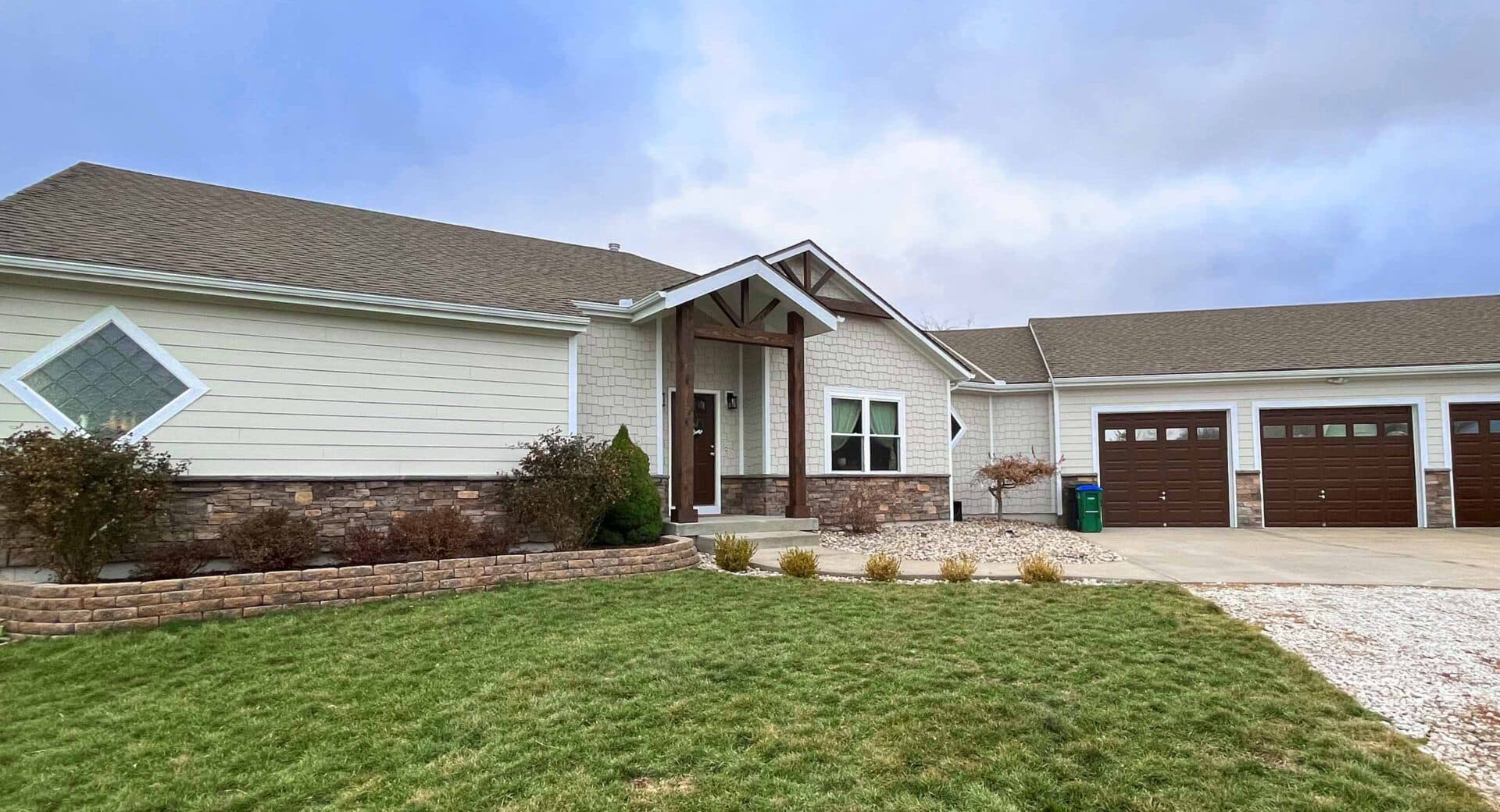 Rock Veneer installation with cobblestone on a home and attached garage