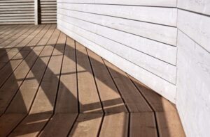 closeup of a wood deck meeting the siding of a home