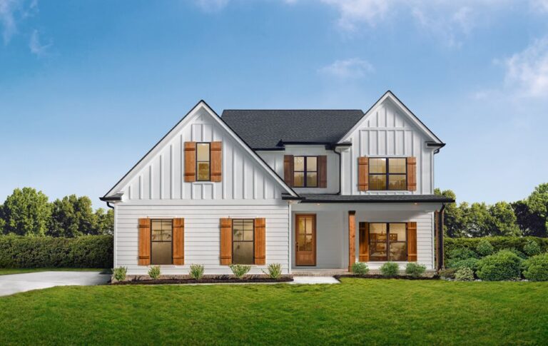 residential home with board and batten siding in the middle of a lush green yard