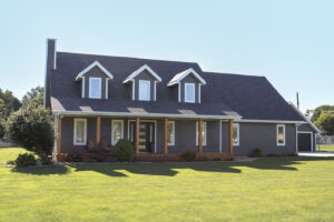 A modern gray house with a gable roof and three dormer windows, showcasing expert craftsmanship by a renowned siding company in Springfield.