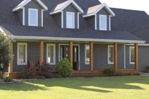 Two-story gray house with a porch, dormer windows, and green lawn in Springfield.