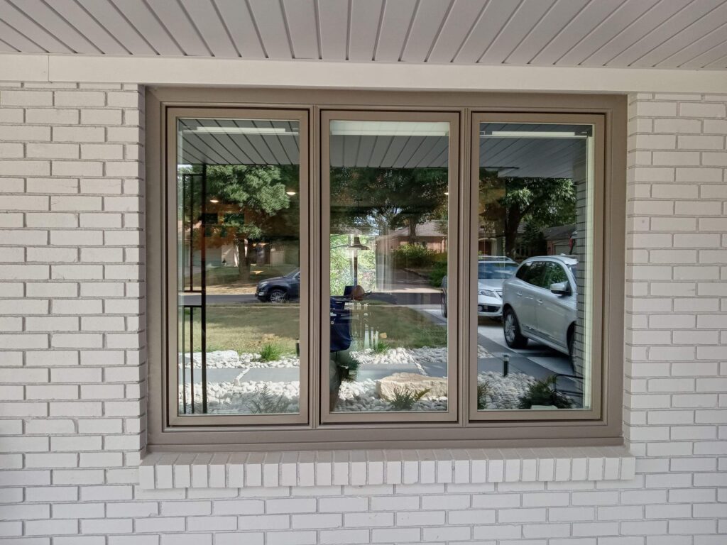 tan trimmed new window installation with brick exterior walls by Xtreme Exteriors in Nixa, MO