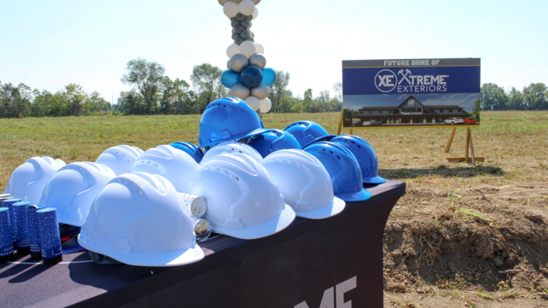 Several white and blue hardhats on a table for Groundbreaking Ceremony of new headquarters construction