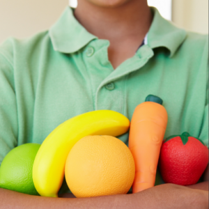 Person with green shirt holding several kinds of fruits in Shawnee, KS