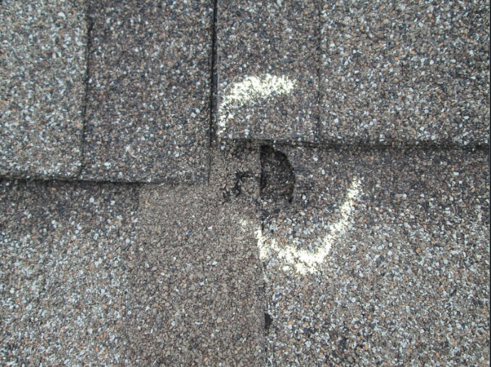 Roof with visible hail damage showing the benefits of impact-resistant shingles.