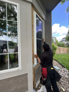 Technician installing energy-efficient window frame during exterior renovation by Xtreme Exteriors