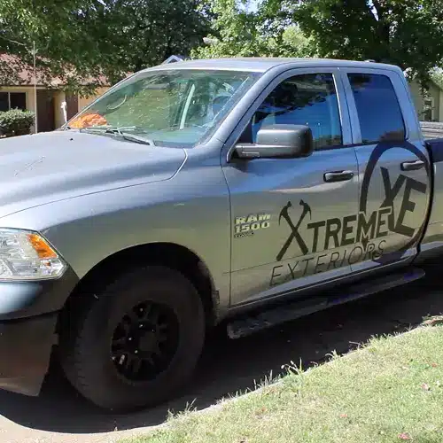 Service truck parked at a residential curb, arriving for emergency siding repair Goodlettsville, by Xtreme Exteriors in Goodlettsville, TN