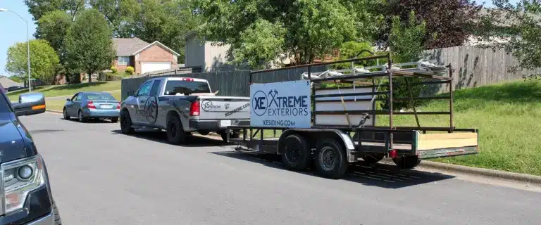 Branded Xtreme Exteriors truck and mobile siding trailer parked curbside for emergency siding repair Nixa by Xtreme Exteriors in Nixa, MO