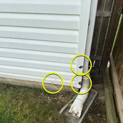 White vinyl siding with multiple punctures and circled damage at ground level requiring emergency siding repair Shawnee