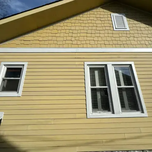 Yellow home with well-maintained siding and white trim - siding maintenance Pittsburg