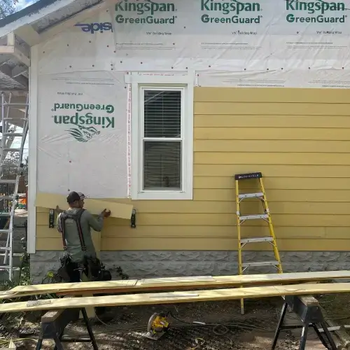 Contractor installing new siding on a house during professional siding maintenance in Pittsburg