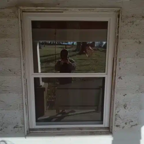 A newly installed white-framed window on a house undergoing siding maintenance by Xtreme Exteriors in Nixa, MO