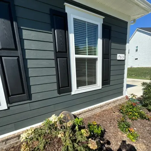 Choosing a siding contractor in Nixa, MO showcased by close-up of modern siding, window trim, and landscaping by Xtreme Exteriors