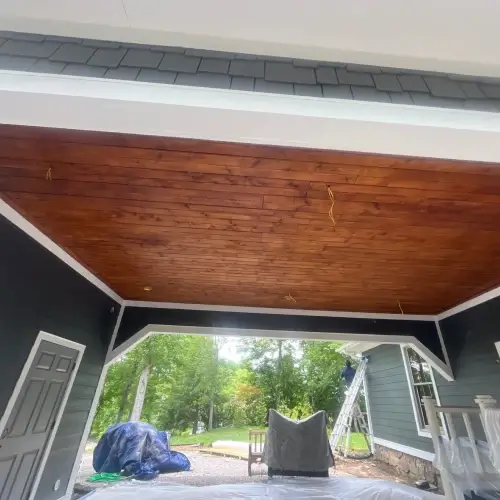 Covered patio featuring blue lap siding, wooden ceiling, and white trim at a Nixa, MO home, highlighting siding options by Xtreme Exteriors