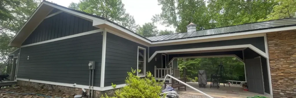 Modern home in Nixa, MO with dark gray lap siding, white trim, stone foundation, and metal roof, providing a visual guide to siding options by Xtreme Exteriors