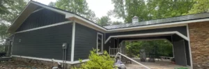 Modern home in Nixa, MO with dark gray lap siding, white trim, stone foundation, and metal roof, providing a visual guide to siding options by Xtreme Exteriors