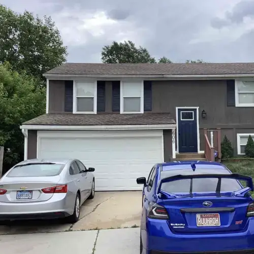 Shawnee home exterior with well-maintained siding, two cars parked in front, and lush trees, demonstrating professional siding maintenance services by Xtreme Exteriors in Nixa, MO.