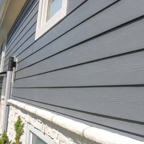 Close-up of modern gray horizontal siding with stone accent, showcasing popular siding styles in Goodlettsville homes - Xtreme Exteriors in Nixa, MO
