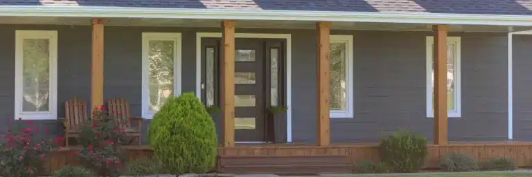 Close-up of a modern home exterior featuring dark gray horizontal siding style, white trim, wooden porch columns, and a contemporary front door, highlighting Xtreme Exteriors' work on siding styles shawnee from Nixa, MO.